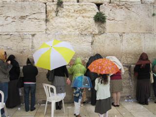People pray at the Western Wall, and write their prayers on papers and jam them into the stones.